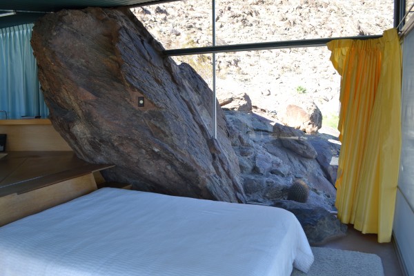 the bedroom area with exposed boulder inside